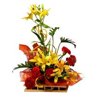 Rakhi and Yellow Lily 6 Red Carnation Flower Arrangement with Rakhi Delivery in India